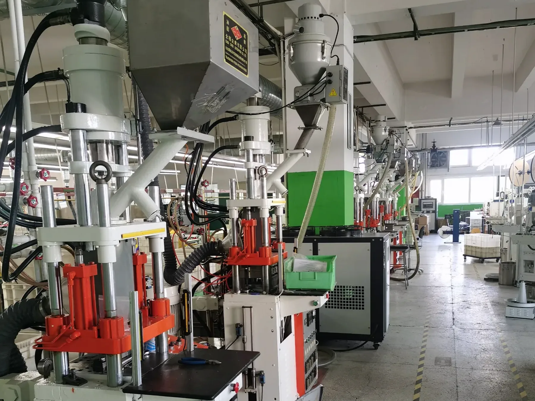 Rows of vertical injection molding equipment inside the MTTJ Tianjin workshop